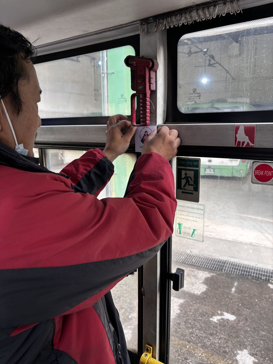 A pregnancy-priority seating sticker inside a public bus